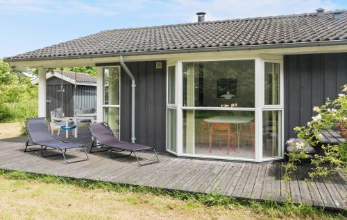 博托比Amazing Home In Væggerløse With Wifi的带纱窗的门廊，露台上摆放着两把椅子和一张桌子