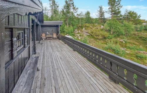 比克勒Koselig Fjellhytte Med Utsikt的建筑物上的木质甲板，配有桌子和椅子