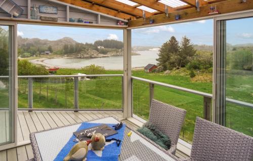 a screened in porch with a table and chairs and windows at Cozy Home In Hellvik With Wifi in Hellvik