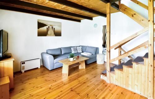 a living room with a blue couch and a table at Pet Friendly Apartment In Suleczyno in Sulęczyno