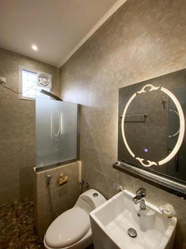 a bathroom with a toilet and a sink and a mirror at منتجع وفلل المرفأ ابها in Abha