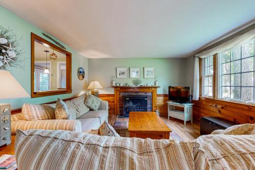 Una sala de estar con dos sofás y una chimenea. en Cape Getaway, en South Yarmouth