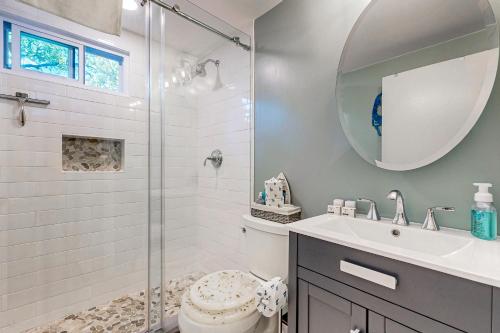 Un baño con ducha, lavabo y espejo. en Cape Getaway, en South Yarmouth