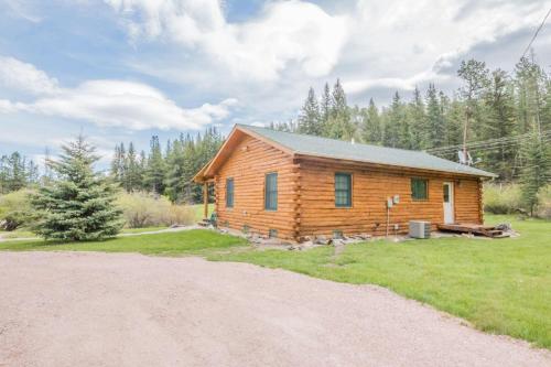 a log cabin with a gravel road in front of it at Tenderfoot Creek Cabin in Custer