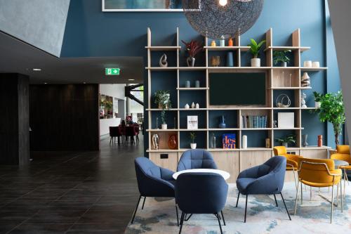 a lobby with chairs and a tv in a building at Crowne Plaza Manchester City Centre by IHG in Manchester