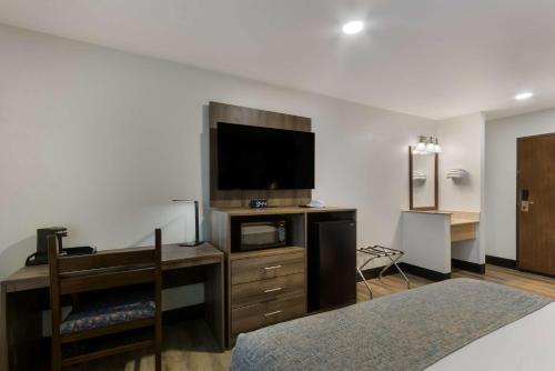 a hotel room with a tv and a desk with a desk sidx sidx sidx sidx at SureStay by Best Western Camp Verde in Camp Verde