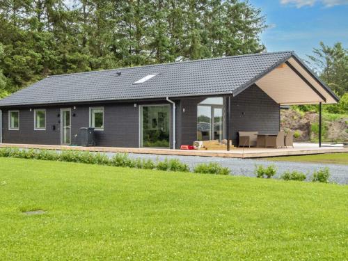 a gray house with a porch and a lawn at 5 star holiday home in Ansager-By Traum in Ansager