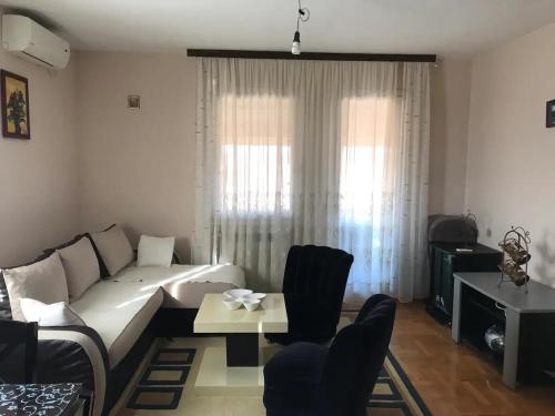 a living room with a white couch and chairs at Apartman Irena in Mali Mokri Lug