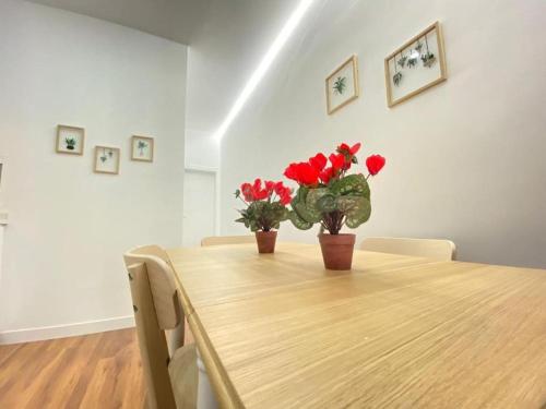 a dining room table with two red flowers on it at Apartment Karin in Arona