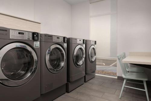 a row of washing machines in a laundry room at Home2 Suites By Hilton Durham University Medical Center in Durham