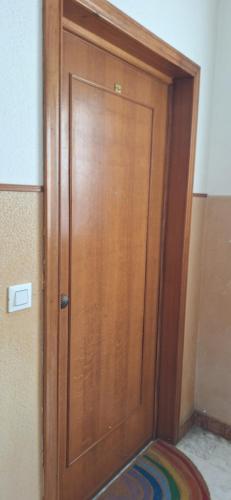 a wooden door in a room with a colorful rug at Attico Morette, terrazzo - whazapp tre due 0 26 ott ott sei 2 quattro in Boissano