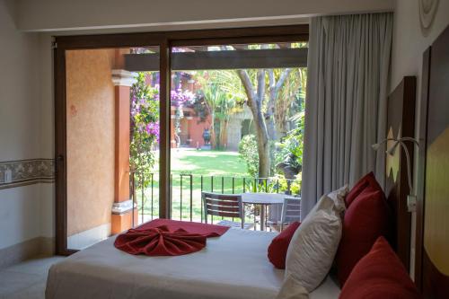a bedroom with a bed with a large sliding glass door at Hosteria Las Quintas Hotel Restaurante Bar in Cuernavaca