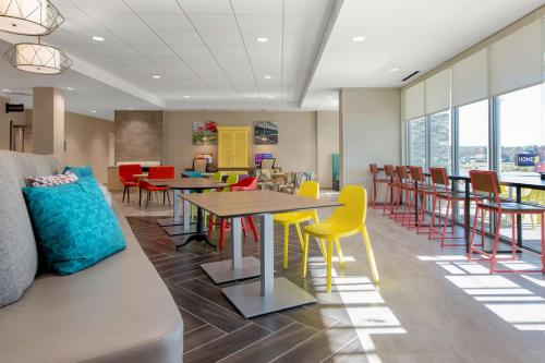 a waiting room with tables and chairs and a cafeteria at Home2 Suites By Hilton Savannah I95 North in Port Wentworth