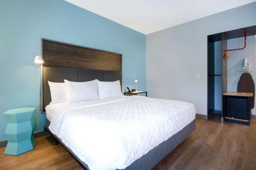 a bedroom with a large bed and blue walls at Tru By Hilton Wake Forest Raleigh North in Wake Forest