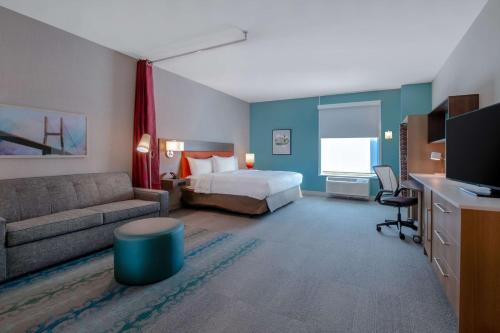 a hotel room with a bed and a couch at Home2 Suites By Hilton Savannah I95 North in Port Wentworth