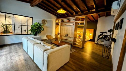 a living room with a couch and a large window at Poblado Muuk Hotel Boutique Campestre in Medellín