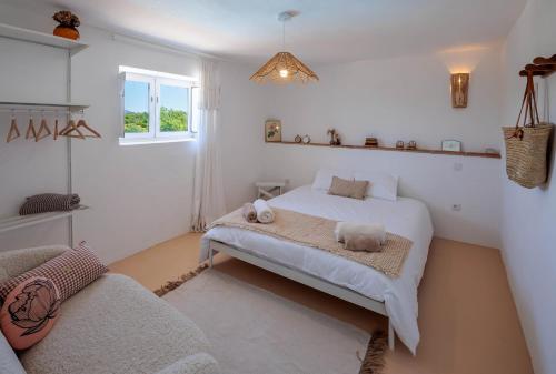 a white bedroom with a bed and a window at La Quinta da Liberdade - Ferme de charme en Algarve in Pechão