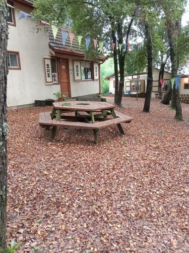 a wooden picnic table in front of a house at Cabañas La Leona in Vilches