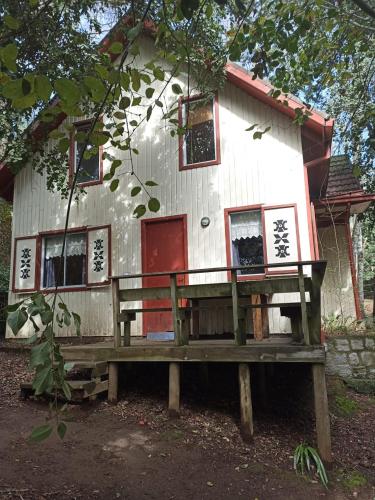 a house with a bench in front of it at Cabañas La Leona in Vilches