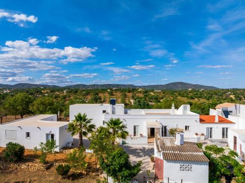an aerial view of a white house with palm trees at La Quinta da Liberdade - Ferme de charme en Algarve in Pechão