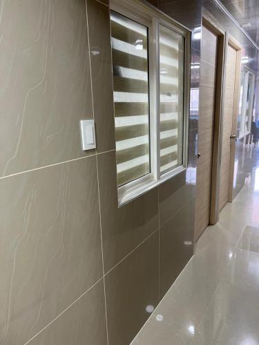 a bathroom with a window and a tile wall at Hotel Orduz Centro Histórico de Cali in Cali