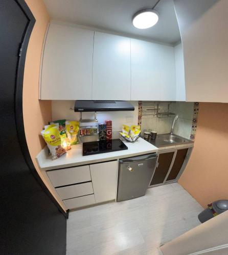 una piccola cucina con mobili bianchi e un lavandino di Gold House Oro a Quito