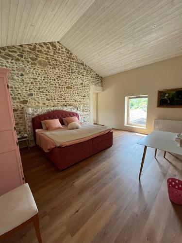 ein Schlafzimmer mit einem Bett und einer Steinwand in der Unterkunft La Bergerie des Amandiers Chambres et Table d'Hôtes in Malataverne