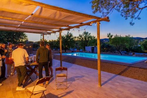 a group of people standing around a table near a pool at La Quinta da Liberdade - Ferme de charme en Algarve in Pechão