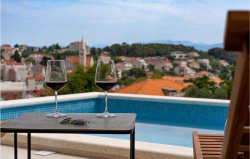 two glasses of wine sitting on a table on a balcony at Awesome Home In Sumartin in Sumartin