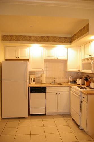a kitchen with white cabinets and a white refrigerator at French Quarter Resort in Branson