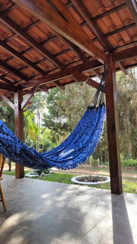 a blue hammock hanging from a wooden pergola at Sitio CANTOS DA FLORESTA in Mairinque