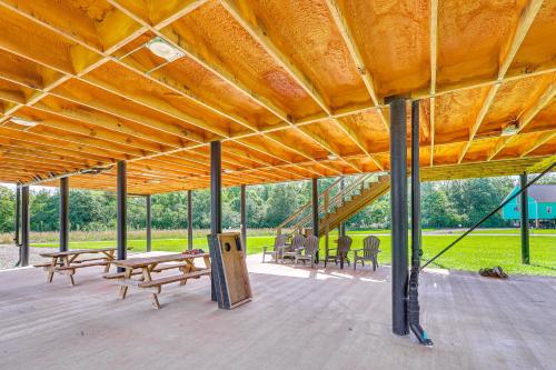 a large pavilion with benches and tables in a field at Family Tradition Glenwood Cabin with River Access! in Glenwood