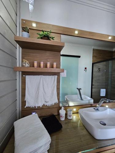 a bathroom with a sink and a mirror at Casa da Flor Guest House – Praia Grande – Beto Carrero in Penha