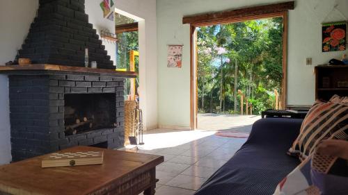 a living room with a fireplace and a couch at Sitio CANTOS DA FLORESTA in Mairinque