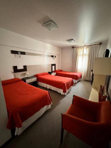 a hotel room with two beds and a chair at Nuevo Mundo in San Rafael