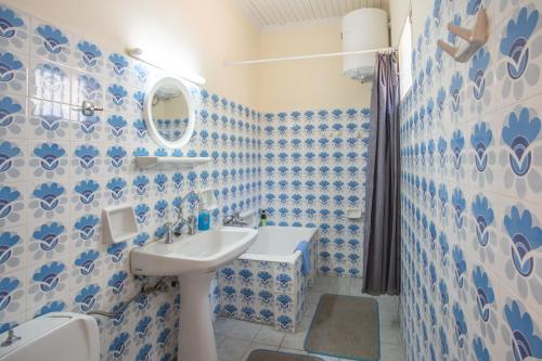 a bathroom with blue and white tiled walls and a sink at GAIA The Cottage House in Nydri