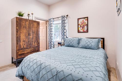 a bedroom with a blue bed and a wooden cabinet at Tucson Vacation Rental Near Downtown and University! in Tucson