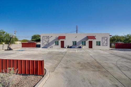 a white building with a red fence in a parking lot at Tucson Vacation Rental Near Downtown and University! in Tucson