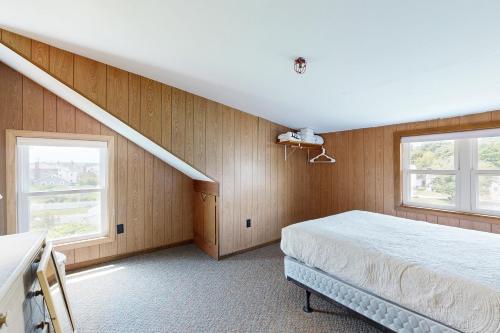 Un dormitorio con una cama y dos ventanas. en Seaglass Cottage, en York