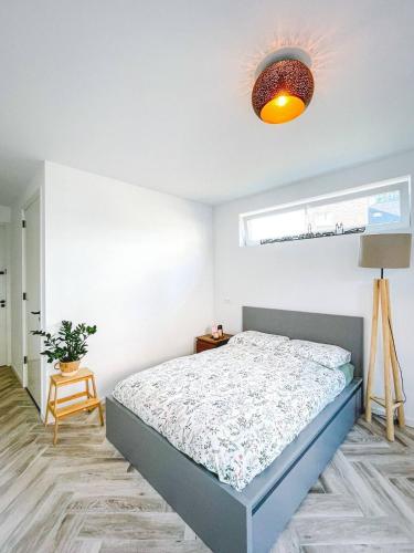 a white bedroom with a bed and a lamp at Modern & Convenient Studio in Arnhem