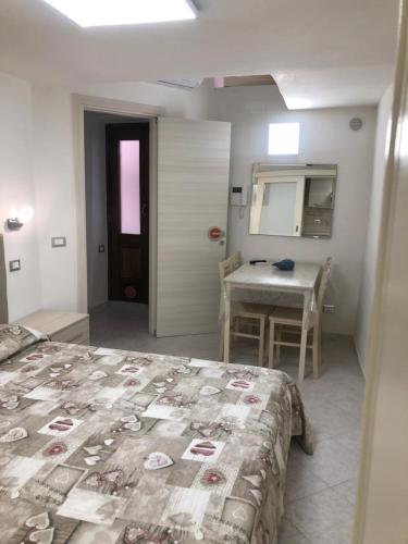 a bedroom with a bed and a table and a mirror at Coral - La Pescheria Casa Vacanze in Gaeta