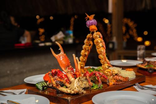 a plate of food on a table with seafood at Paradise Beach Hotel & Resort in West Bay