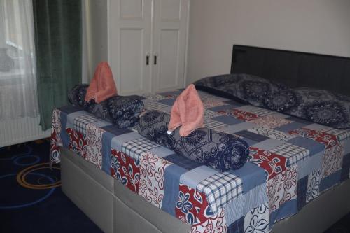 a bed with red and blue covers and pink shoes on it at Tanzanit in Štúrovo