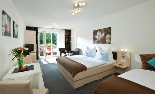 um quarto de hotel com uma cama e uma sala de estar em Haus Maria em Bad Kleinkirchheim