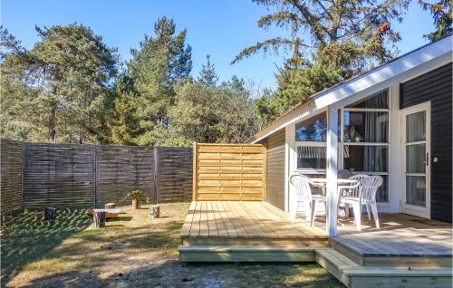 a small house with a deck and a table at Nice Home In Nexø With Wifi in Neksø