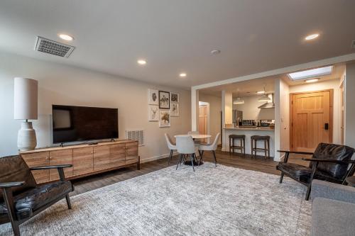 a living room with a flat screen tv and a table at Bavarian Lodge Suites in Leavenworth