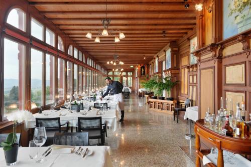 a man walking through a dining room with tables at Jugendstilhotel Paxmontana in Sachseln