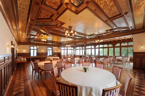 a dining room with tables and chairs and ceilings at Jugendstilhotel Paxmontana in Sachseln