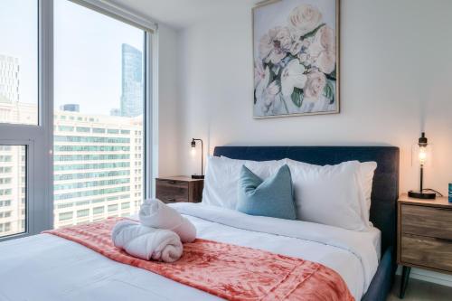 a bedroom with a bed with a stuffed animal on it at RivetStays - The Jarvis in Toronto