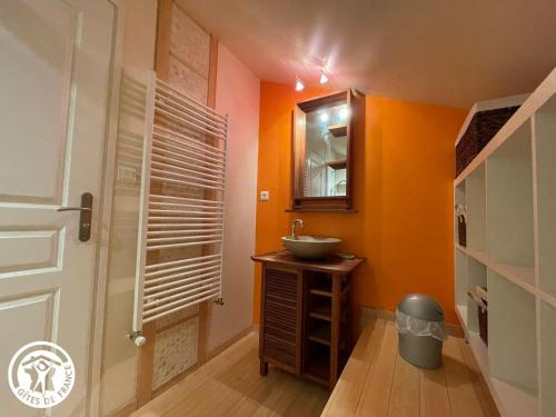 a bathroom with orange walls and a sink and a mirror at Grange rénovée avec piscine privative - 4 ch, jardin clos, à 7 km d'Indian Forest - FR-1-426-304 in Le Champ-Saint-Père